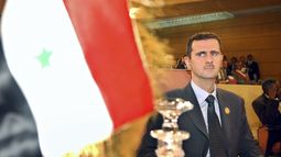 ARCHIVO - El presidente de Siria, Bashar Assad, mira a la bandera de su país en la apertura de la 16ta sesión ordinaria de la Cumbre Árabe en Túnez, el 22 de mayo de 2004. (AP Foto/Amr Nabil, Archivo)