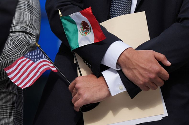 ARCHIVO – Una persona sostiene las banderas estadounidense y mexicana en una conferencia de prensa, en Chicago, el 4 de septiembre de 2025. (AP Foto/Nam Y. Huh, Archivo)
