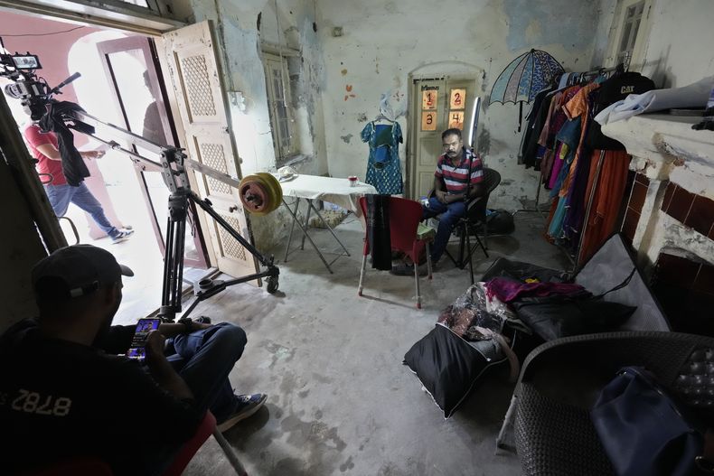 Dos técnicos se toman un descanso durante la grabación de la telenovela Tan Man Neel-o-Neel (Profundamente enamorados), el sábado 2 de noviembre de 2024, en Rawalpindi, Pakistán. (AP Foto/Anjum Naveed)