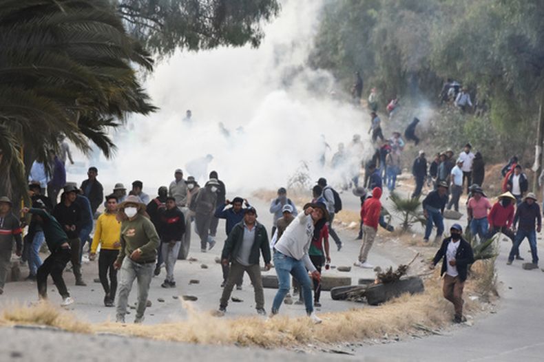 Manifestantes antigubernamentales que bloquean una autopista lanzan piedras contra la policía militar durante los enfrentamientos en Vinto, Bolivia, el lunes 8 de junio de 2026. (Foto AP/Dico Soliz)