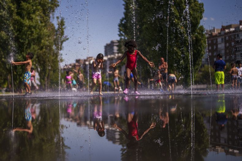 En esta imagen de archivo, un grupo de niños se refrescan en una playa urbana en el parque Madrid Río, en Madrid, el 26 de junio de 2023. (AP Foto/Manu Fernández, archivo)