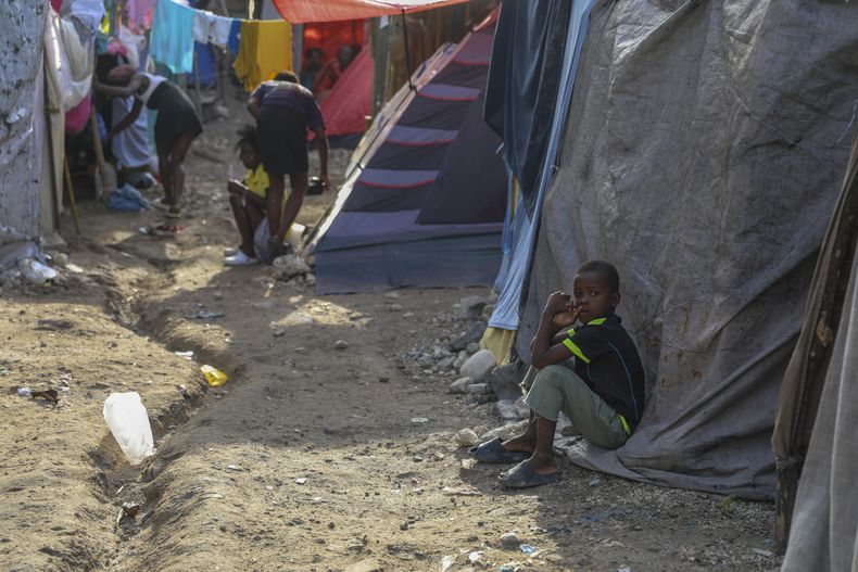 Varias personas se refugian en una escuela abandonada transformada en albergue tras verse obligadas a abandonar sus hogares debido a un ataque de las pandillas en Puerto Príncipe, Haití, martes 29 de octubre de 2024. (AP Foto/Odelyn Joseph)