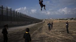 Palestinos desplazados del norte de la Franja de Gaza por los bombardeos israelíes juegan cerca de la frontera con Egipto, el domingo 14 de enero de 2024, en Rafah, en el sur de Gaza. (AP Foto/Fatima Shbair, Archivo)