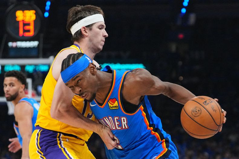 Shai Gilgeous-Alexander, base del Thunder de Oklahoma City, elude a Austin Reaves, de los Lakers de Los Ángeles, el martes 5 de mayo de 2026 (AP Foto/Kyle Phillips)