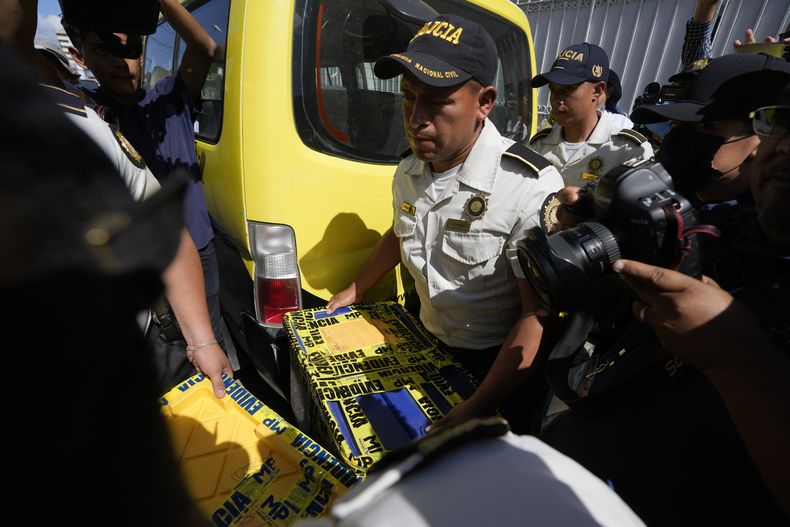 Agentes de policía cargan una caja con evidencias recogidas en la sede del Movimiento Semilla en Ciudad de Guatemala, el viernes 21 de julio de 2023. La policía guatemalteca allanó las oficinas del candidato presidencial Bernardo Arévalo como parte de una investigación sobre presuntas irregularidades en la formación del partido. (AP Foto/Moisés Castillo)