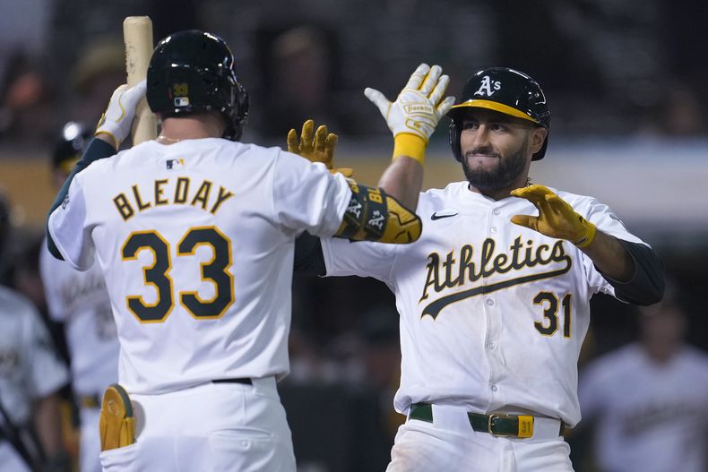 El venezolano Abraham Toro recibe la felicitación de JJ Bleday, su compañero en los Atléticos de Oakland, tras conectar un jonrón en el duelo del martes 21 de mayo de 2024, ante los Rockies de Colorado (AP Foto/Jeff Chiu)
