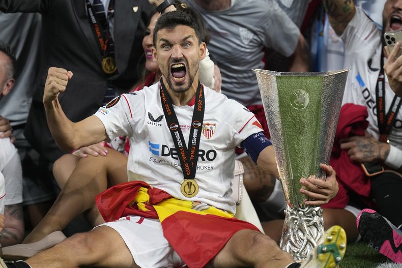 Jesús Navas, del Sevilla, festeja con el trofeo de la Liga Europa, tras derrotar e penales a la Roma en Budapest, el jueves 1 de junio de 2023 (AP Foto/Darko Bandic)