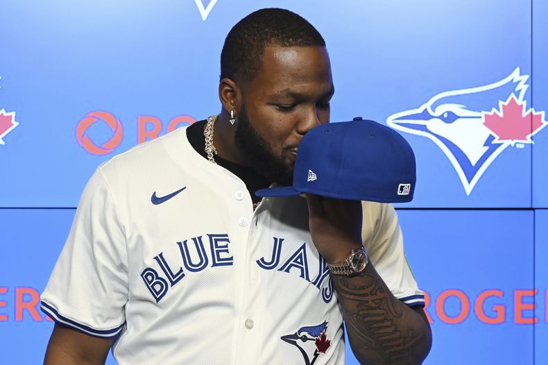 El primera base de los Azulejos de Toronto Vladimir Guerrero Jr. le da un beso a su gorra del equipo durante la conferencia de prensa para anunciar su contrato de 14 años y 500 millones de dólares el lunes 14 de abril del 2025. (Jon Blacker/The Canadian Press via AP)