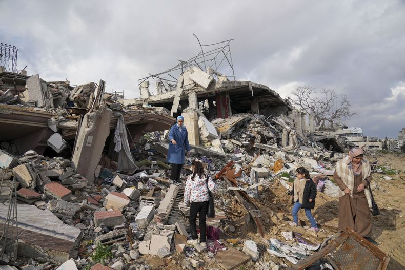 Miembros de la familia Dwaima, sobre las ruinas de su vivienda, que fue arrasada por un ataque aéreo israelí durante la guerra entre Israel y Hamás, en el vecindario de Tal al Hawa de la Ciudad de Gaza, el 24 de febrero de 2025. (AP Foto/Abdel Kareem Hana)