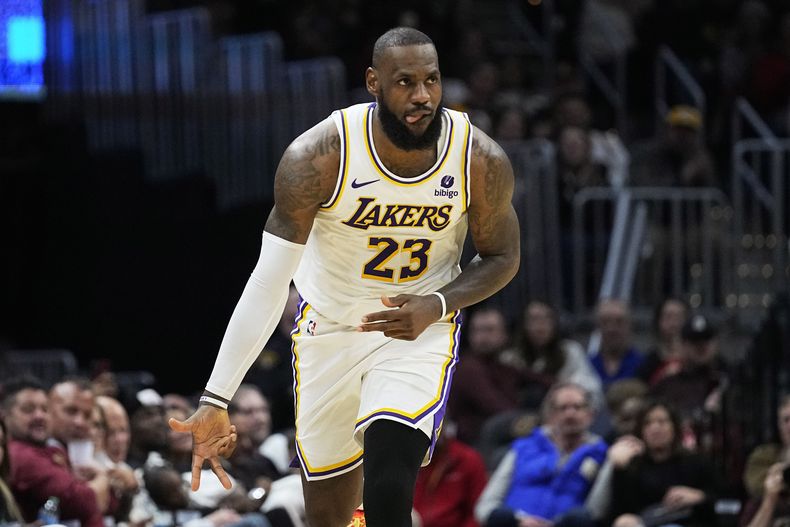 LeBron James, alero de los Lakers de Los Ángeles, festeja luego de atinar un triple ante los Cavaliers de Cleveland, el sábado 25 de noviembre de 2023 (AP Foto/Sue Ogrocki)