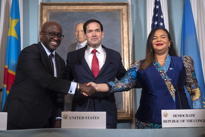 El secretario de Estado de EEUU, Marco Rubio, en el centro, junto al ministro de Asuntos Exteriores de Ruanda, Olivier Nduhungirehe, a la izquierda, y la ministra de Asuntos Exteriores de la República Democrática del Congo, Therese Kayikwamba Wagner, a la derecha, mientras se dan la mano tras firmar un acuerdo de paz en el Departamento de Estado de EEUU, el viernes 27 de junio de 2025, en Washington. (AP Foto/Mark Schiefelbein).