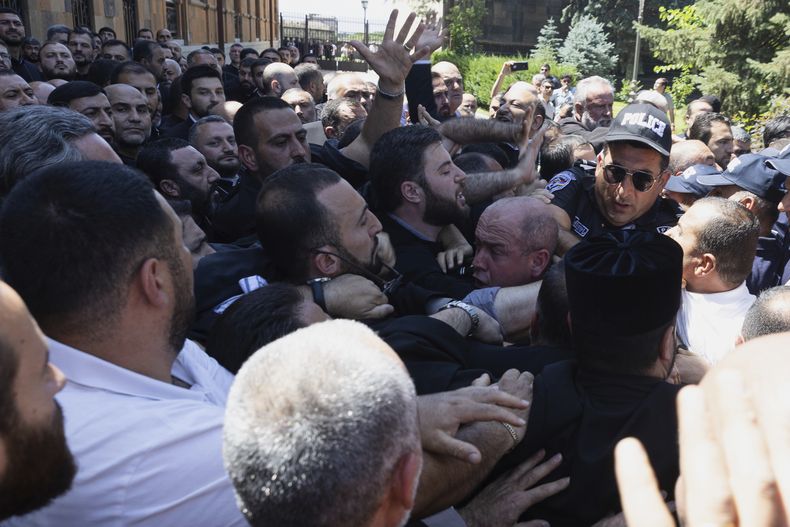 Agentes del Servicio de Seguridad Nacional de Armenia se enfrentan con fieles a su llegada para arrestar a Mikael Ajapahyan, arzobispo de Gyumri y Shirak, en Echmiadzin, sede de la Iglesia Apostólica Armenia, en las afueras de Ereván, Armenia, el viernes 27 de junio de 2025. (Grigor Yepremyan, PAN Foto vía AP)