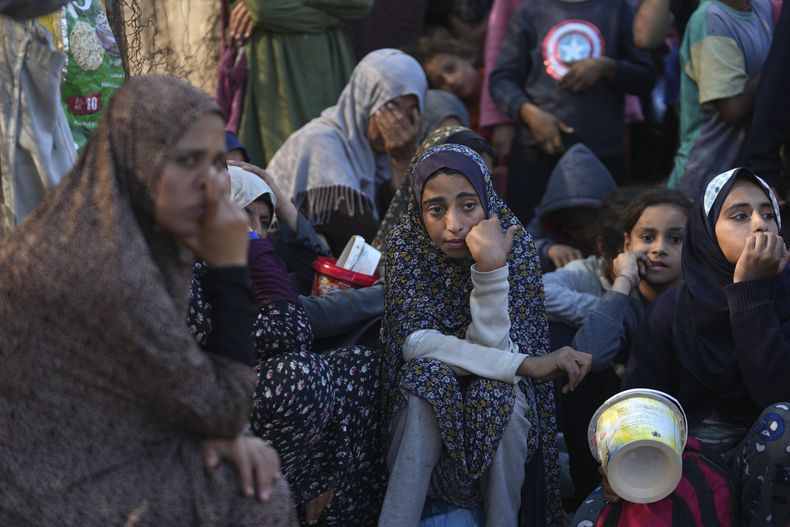 Palestinos esperan en fila a recibir comida el lunes 18 de noviembre de 2024, en Deir al-Balah, Franja de Gaza. (AP Foto/Abdel Kareem Hana)
