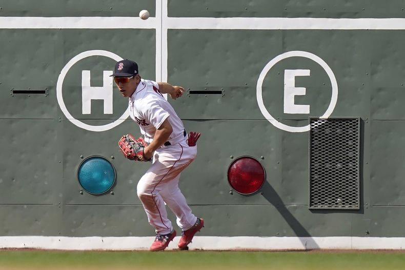 Masataka Yoshida de los Medias Rojas de Boston intenta recuperar la pelota tras un doble de Brandon Belt de los Azulejos de Toronto, el domingo 6 de agosto de 2023, en Boston. (AP Foto/Steven Senne)