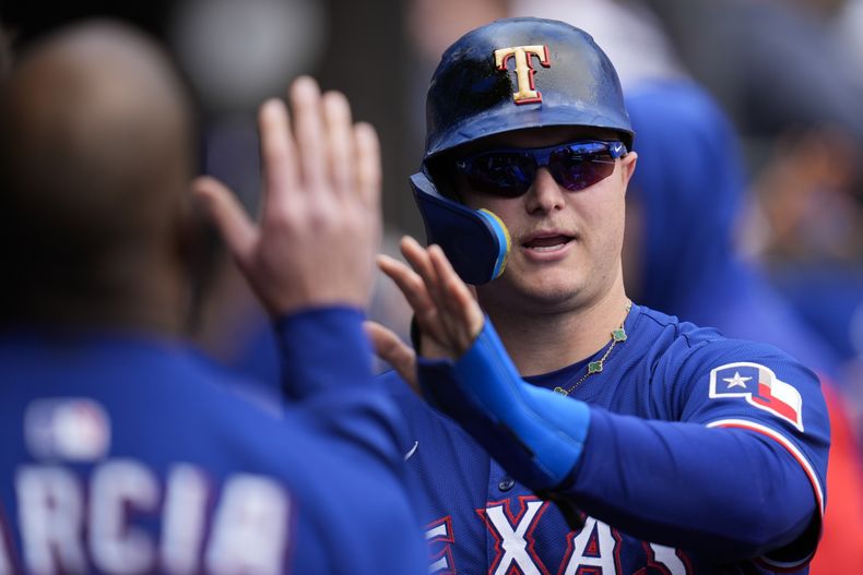 El bateador designado de los Rangers de Texas, Joc Pederson (4), celebra después de anotar con un elevado de sacrificio de Marcus Semien (2) durante la cuarta entrada de un partido de béisbol contra los Medias Blancas de Chicago, el sábado 24 de mayo de 2025, en Chicago. (AP Photo/Erin Hooley)