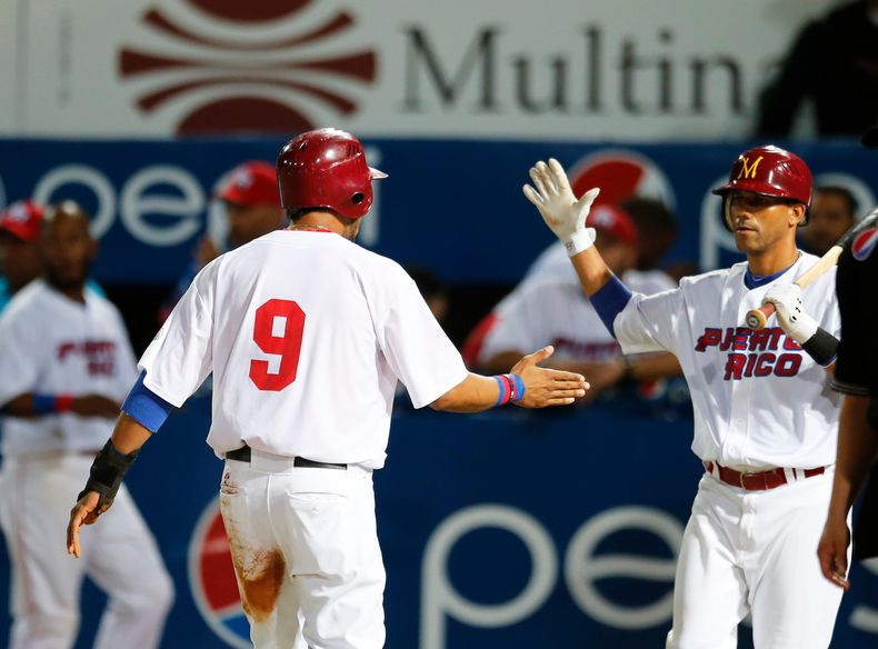 Eddie Rosario (9), jardinero de Puerto Rico, celebra con su compa&ntilde;ero Luis Figueroa, tras anotar una carrera contra Venezuela en la Serie del Caribe, el mi&eacute;rcoles 5 de febrero de 2014, en Porlamar (AP Foto/Fernando Llano)
