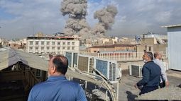 Varias personas observan mientras una columna de humo señala el lugar donde se produjo una explosión en Teherán, Irán, el 28 de febrero de 2026. (AP Foto)