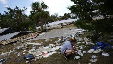 Lainey Hamelink, de 9 años, cuya familia era dueña de la propiedad contigua, ayuda a recoger vajilla desparramada en el Tinas Dockside Inn, totalmente destruido por el huracán Idalia en Horseshoe Beach, Florida, 1 de setiembre de 2023, dos días después del paso de la tormenta. (AP Foto/Rebecca Blackwell)