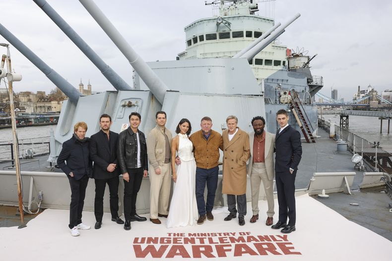 Jerry Bruckheimer, de izquierda a derecha, Alex Pettyfer, Henry Golding, Henry Cavill, Eiza González, el director Guy Ritchie, Cary Elwes, Babs Olusanmokun y Hero Fiennes Tiffin posan en el HMS Belfast en una sesión fotográfica de la película The Ministry Of Ungentlemanly Warfare el 22 de marzo de 2024 en Londres. (Foto Vianney Le Caer/Invision/AP)
