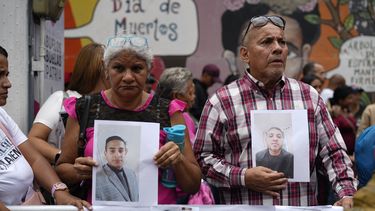 Varias personas que sostienen fotografías de parientes migrantes --de los que dicen fueron detenidos en Estados Unidos y aguardan a ser deportados-- participan en una manifestación organizada por el gobierno en Caracas, Venezuela, el martes 18 de marzo de 2025, para protestar por la deportación de presuntos miembros de la pandilla venezolana Tren de Aragua, que fueron transferidos a una cárcel en El Salvador. (AP Foto/Ariana Cubillos)