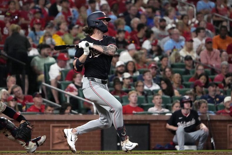 Jesse Winker de los Nacionales de Washington batea un sencillo remolcador en la tercera entrada del juego ante los Cardenales de San Luis el domingo 27 de julio del 2024. (AP Foto/Jeff Roberson)