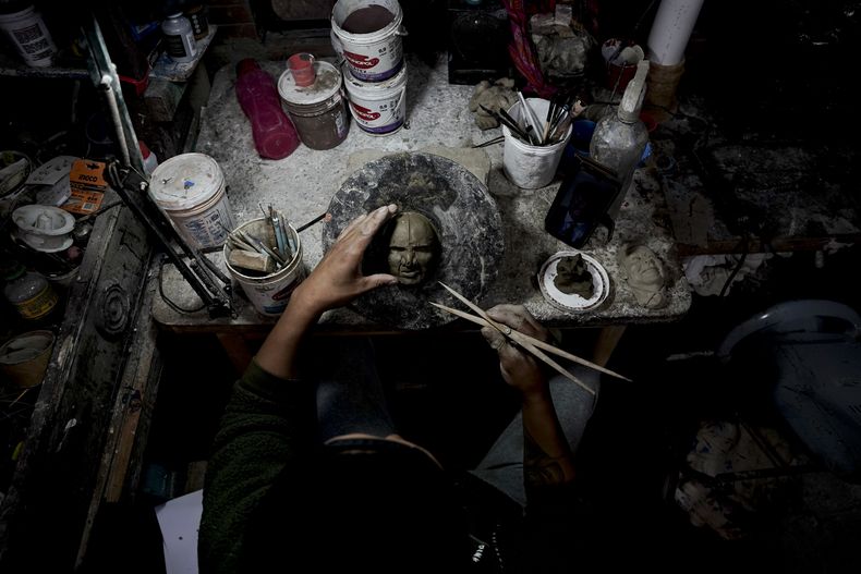 El artesano William Luna crea una máscara de una persona real para adornar el tantawawa, un pan dulce tradicional para las celebraciones del Día de los Muertos, en La Paz, Bolivia, el jueves 31 de octubre de 2024. (Foto AP/Freddy Barragán)