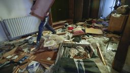 Un hombre camina junto a un retrato roto del difunto presidente sirio Hafez Assad mientras la gente busca pertenencias en la residencia privada saqueada del presidente sirio Bashar Assad en el distrito de Malkeh de Damasco, Siria, el domingo 8 de diciembre de 2024. (AP foto/Hussein Malla)