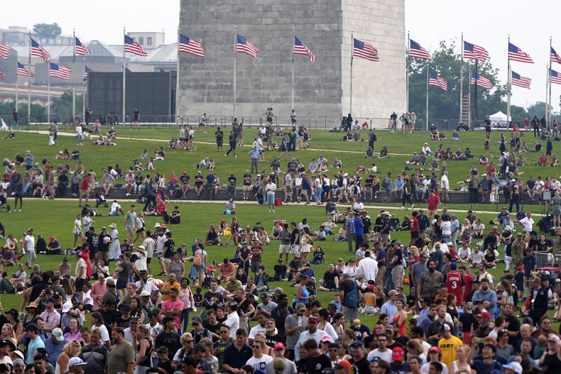 Personas en el césped alrededor del Monumento a Washington mientras el presidente Donald Trump asiste a un desfile militar para conmemorar el 250mo aniversario del Ejército, que coincide con su 79no cumpleaños, el sábado 14 de junio de 2025, en Washington. (AP Foto/Julia Demaree Nikhinson)