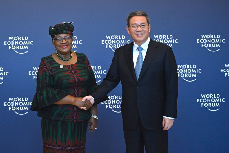ARCHIVO - El premier chino, Li Qiang, a la derecha, estrecha la mano de la directora general de la Organización Mundial del Comercio, Ngozi Okonjo-Iweala, en Tianjin, antes de la reunión anual de Nuevos Campeones del Foro Económico Mundial, el lunes 26 de junio de 2023. (Wang Zhao/Pool Foto via AP, Archivo)