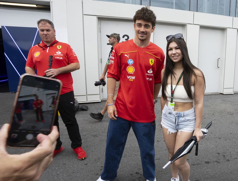 El piloto de Ferrari Charles Leclerc posa para una foto con una fanática en el Gran Premio de Canadá, el jueves 6 de junio de 2024, en Montreal. (Ryan Remiorz/The Canadian Press vía AP)