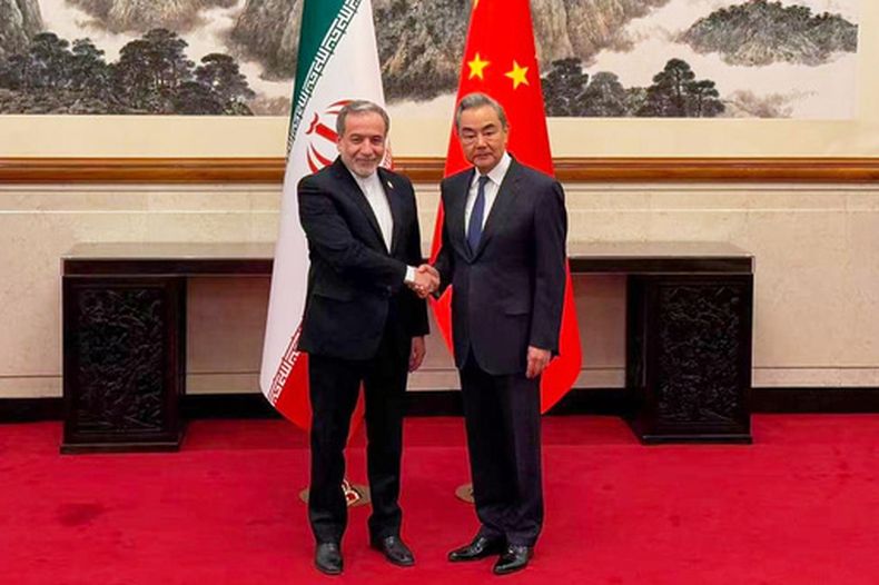 En esta imagen, distribuida en el canal de Telegram del ministro de Exteriores de Irán, Abbas Araghchi, el ministro de Exteriores de China, Wang Yi (derecha), saluda a Araghchi en Beijing, China, el 6 de mayo de 2026. (Canal de Telegram del ministro de Exteriores de Irán vía AP)