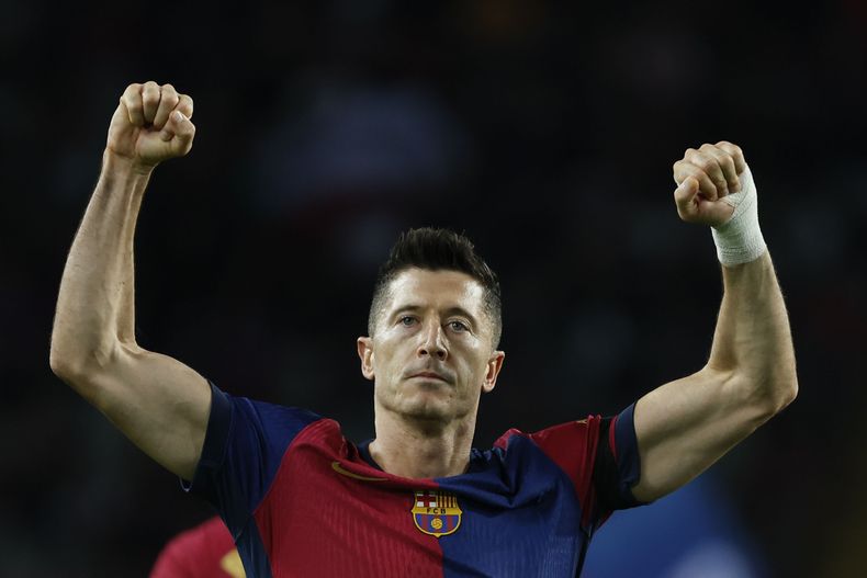 Robert Lewandowski festeja tras anotar de penal el primer gol del Barcelona ante el Sevilla en el partido de la Liga española, el domingo 20 de octubre de 2024, en Barcelona. (AP Foto/Joan Monfort)