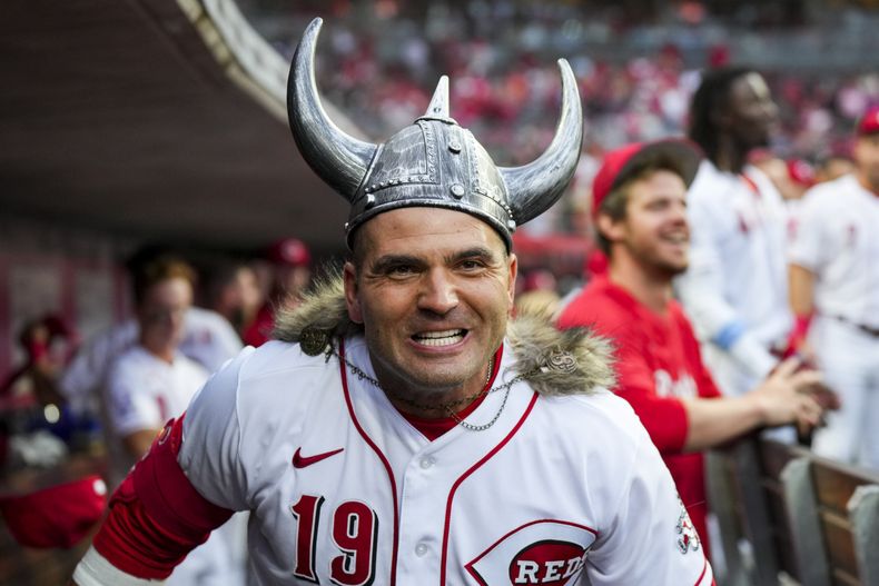 Joey Votto, de los Rojos de Cincinnati, celebra en la caseta después de batear un cuadrangular solitario durante la quinta entrada del juego de béisbol en contra de los Rockies de Colorado, en Cincinnati, el lunes 19 de junio de 2023. (AP Foto/Aaron Doster)