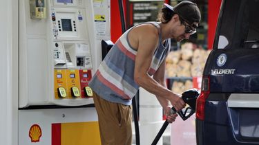 ARCHIVO - Patrick Coffin, residente en Oregón, llena el tanque de su coche en una gasolinera de Portland, Oregón, el 4 de agosto de 2023. (AP Fo/Claire Rush, Archivo)