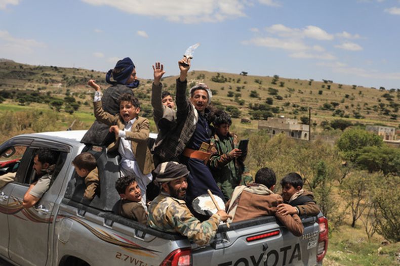 Civiles yemeníes celebran en la parte trasera de una camioneta en el distrito de Bani Matar, Yemen, el sábado 12 de septiembre de 2026, mientras siguen un convoy de prisioneros hutíes liberados en Moca camino de Saná, tras la toma hutí de la ciudad portuaria en el mar Rojo. (AP Foto/STR)