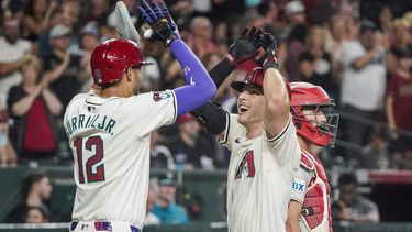 Jake McCarthy de los Diamondbacks de Arizona le da los cinco al cubano Lourdes Gurriel Jr. tras su jonrón en la quinta entrada ante los Filis de Filadelfia el sábado 10 de agosto del 2024. (AP Foto/Darryl Webb)
