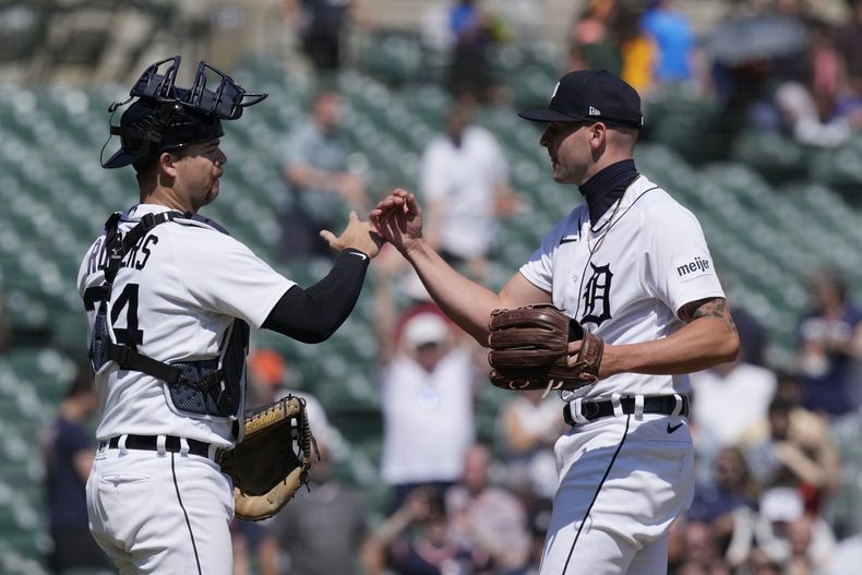 El receptor Jake Rogers y el relevista Alex Lange tras la victoria de los Tigres de Detroit por 3-2 ante los Rangers de Texas, el miércoles 31 de mayo, en Detroit. (AP Foto/Carlos Osorio)