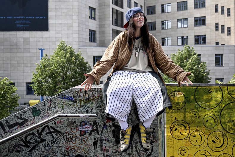 Billie Eilish sentada en el barandal de una escalera conocida como la pared de Billie Eilish en Berlín el viernes 7 de junio de 2024. (Britta Pedersen/dpa vía AP)