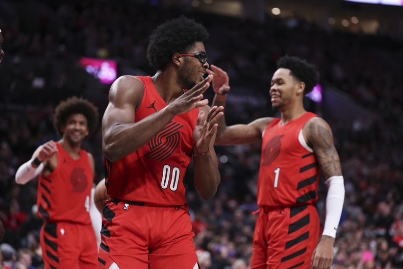 De izquierda a derecha, Matisse Thybulle, Scoot Henderson y Anfernee Simons, de los Trail Blazers de Portland, festejan durante el partido ante los Kings de Sacramento, el martes 26 de diciembre de 2023 (AP Foto/Howard Lao)