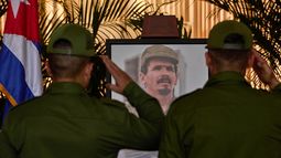 Personal militar saluda junto a una fotografía de Ramiro Valdés mientras rinde su último respeto a una de las últimas figuras prominentes de la Revolución Cubana, durante su funeral en La Habana, Cuba, el martes 23 de junio de 2026. (AP Foto/Ramón Espinosa)