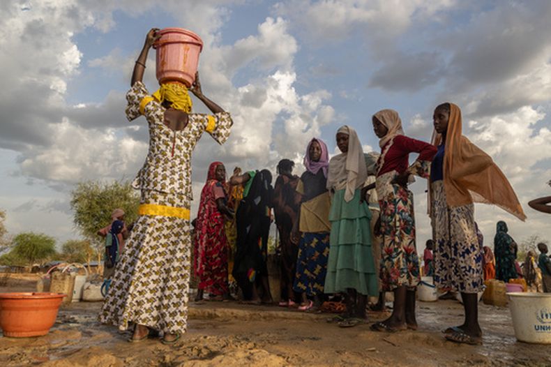 ARCHIVO - Mujeres y niños recogen agua al atardecer en el campamento de refugiados de Korsi en Birao, República Centroafricana, el 27 de marzo de 2026. (Foto AP/Caitlin Kelly, archivo)