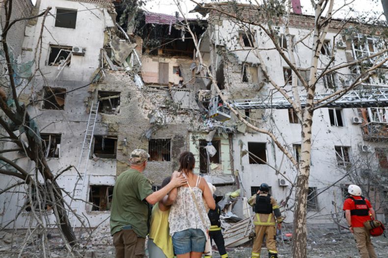 Residentes miran a su casa en ruinas tras un ataque de una bomba guiada rusa en Zaporiyia, Ucrania, el domingo 19 de julio de 2026. (AP Foto/Kateryna Klochko)