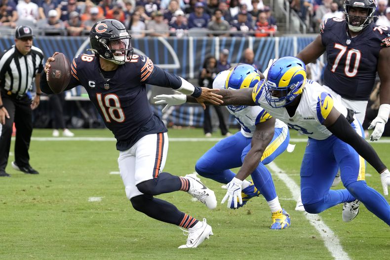 El quarterback de los Bears de Chicago, Caleb Williams, intenta eludir a dos defensores de los Rams de Los Ángeles durante la primera mitad de un partido el domingo 29 de septiembre de 2024, en Chicago. (AP Foto/Nam Y. Huh)
