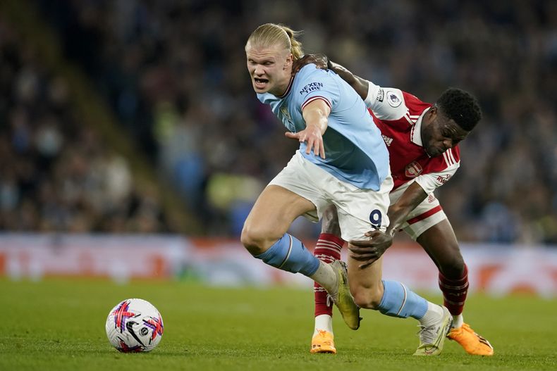 Thomas Partey (derecha) de Arsenal trata de retener a Erling Haaland del Manchester City en la Liga Premier, el miércoles 26 de abril de 2023, en Manchester. (AP Foto/Dave Thompson)