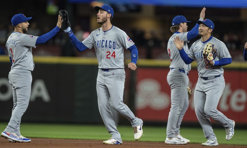 Nick Madrigal, Cody Bellinger, Nico Hoerner y Seiya Suzuki, de izquierda a derecha, celebran la victoria de los Cachorros de Chicago en el partido de béisbol contra los Marineros de Seattle, el sábado 13 de abril de 2024, en Seattle. (AP Foto/Stephen Brashear)