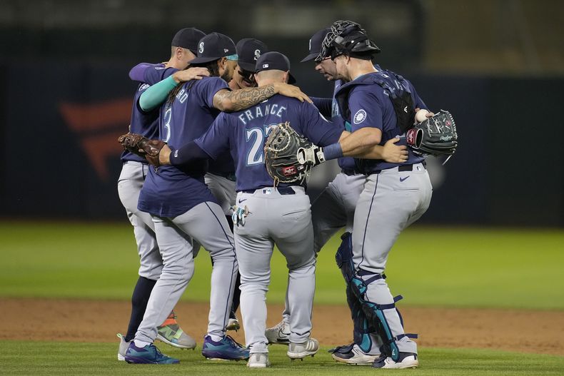 Jugadores de los Marineros de Seattle celebran después de derrotar a los Atléticos de Oakland en un partido de béisbol en Oakland, California, el martes 4 de junio de 2024. (AP Foto/Jeff Chiu)