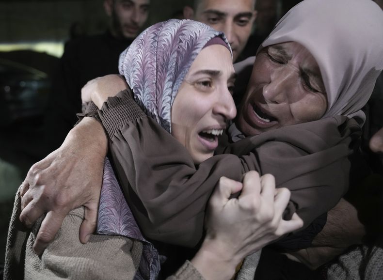 Shuruq Dwayat, izquierda, una presa palestina liberada por Israel, es abrazada por familiares a su llegada a su hogar en Sur Bahar, un vecindario del sur de Jerusalén, la madrugada del domingo 26 de noviembre de 2023. (AP Foto/Mahmoud Illean)