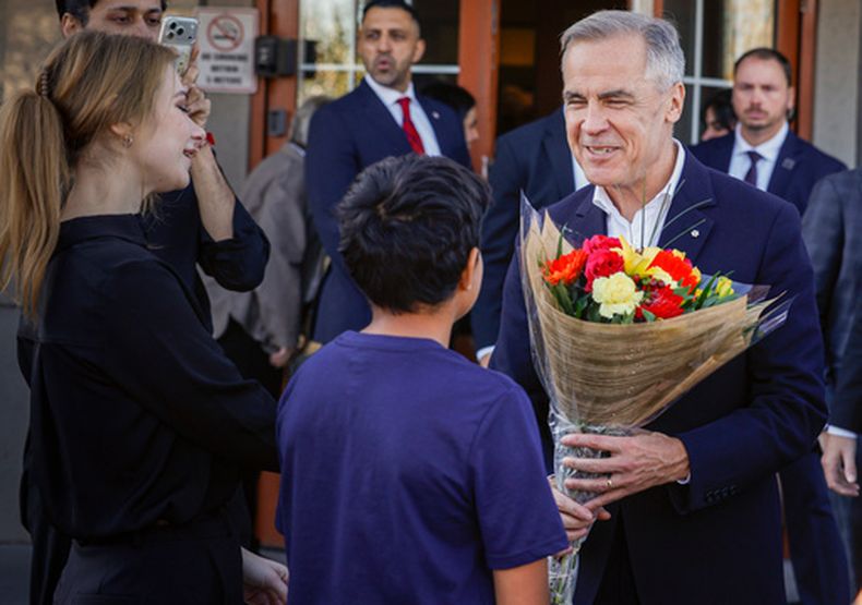 El primer ministro canadiense Mark Carney, derecha, se reúne con simpatizantes en un restaurante en Calgary, Canadá, el jueves 15 de octubre de 2026. (Jeff McIntosh/The Canadian Press vía AP)