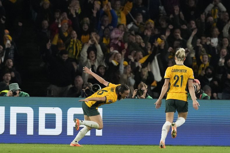 Hayley Raso (izquierda) celebra tras anotar el segundo gol de Australia en la victoria 2-0 ante Dinamarca en los octavos de final del Mundial femenino, el lunes 17 de agosto de 2023, en Sydney. (AP Foto/Mark Baker)