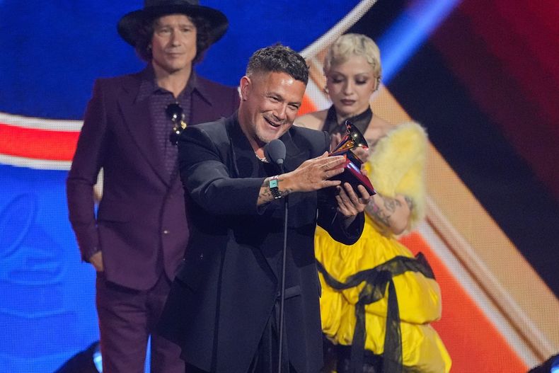 Alejandro Sanz recibe el premio a la grabación del año por Palmeras en el jardín durante los Latin Grammy 2025, el jueves 13 de noviembre de 2025, en el MGM Grand de Las Vegas. Desde la izquierda, en primer plano, los presentadores Enrique Bunbury y Mon Laferte. (Foto AP/Chris Pizzello)